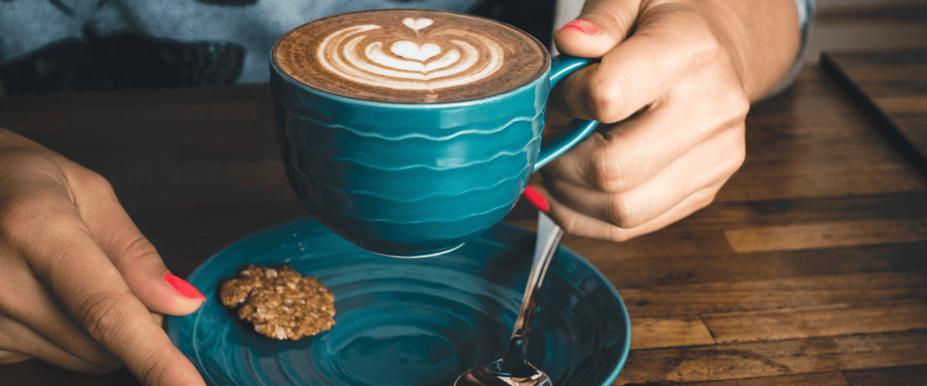 Woman holding cup of coffee in cafe
