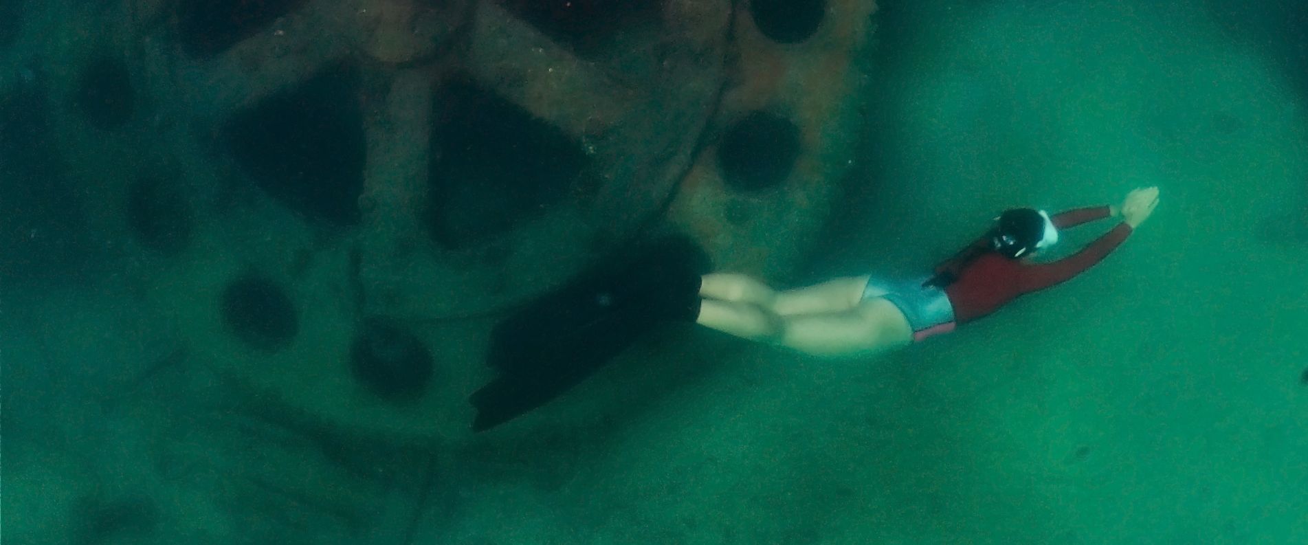 woman swimming around shipwreck